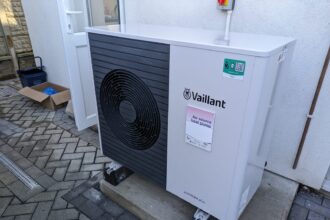 An air-source heat pump unit beside a house wall