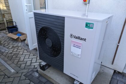 An air-source heat pump unit beside a house wall